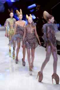 ALEXANDER MCQUEEN L'ENFANT PRODIGE DELLA MODA 4 Modella in passerella con le iconiche scarpe Armadillo e abito con stampa digitale rettiliana, collezione Plato's Atlantis.